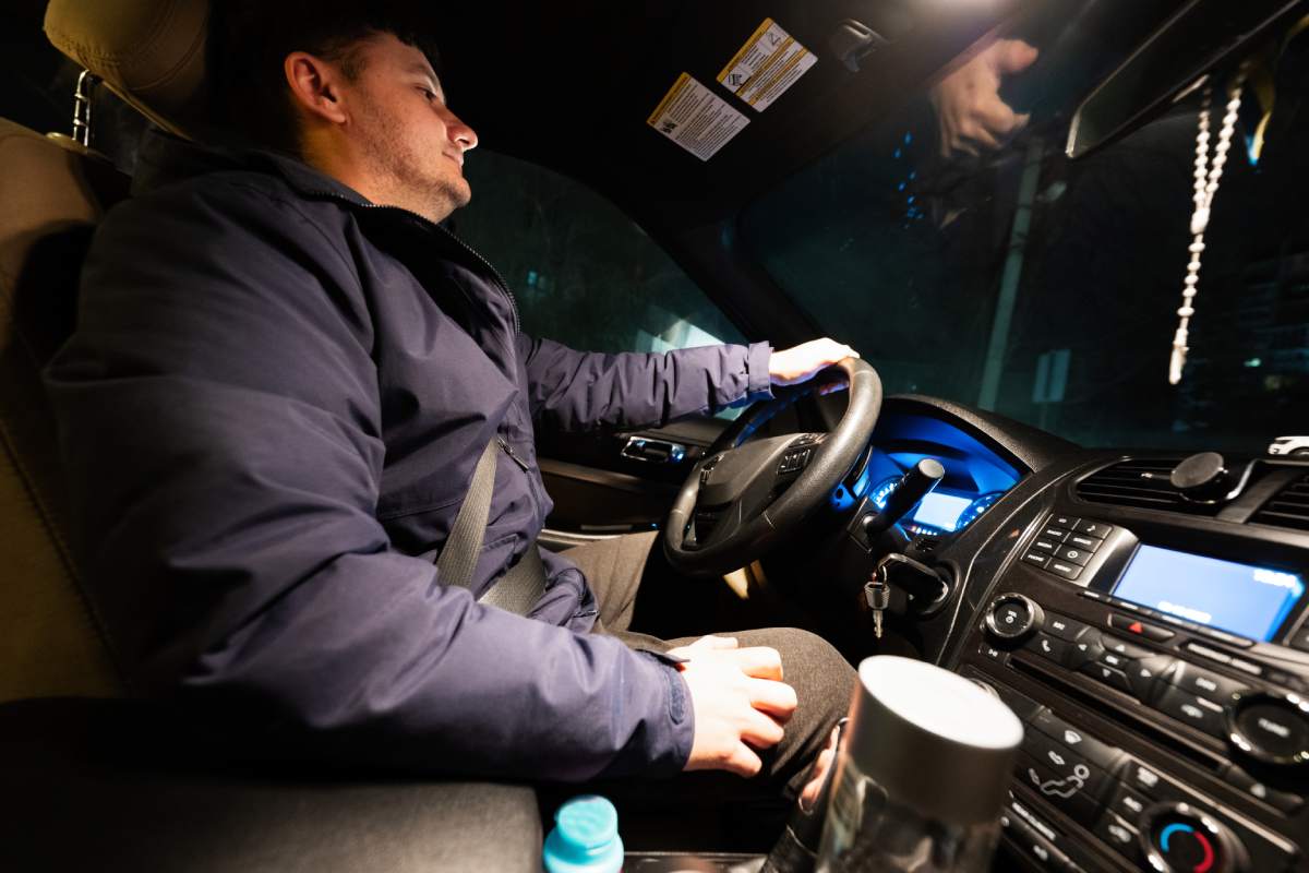 Man driving a car on the road at night.