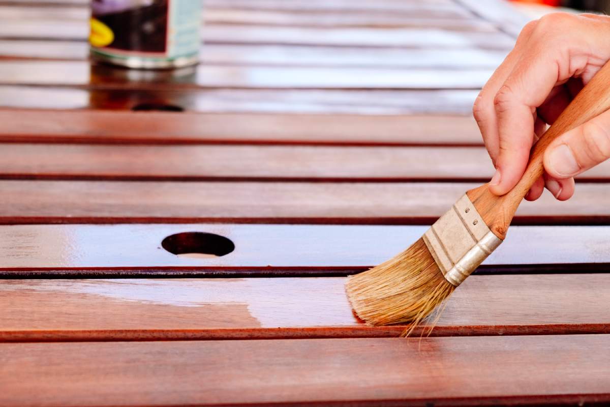 Apply teak oil on the boards of a wooden table to protect it from bad weather.