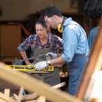 Carpenter and his assistant working together in a carpentry workshop