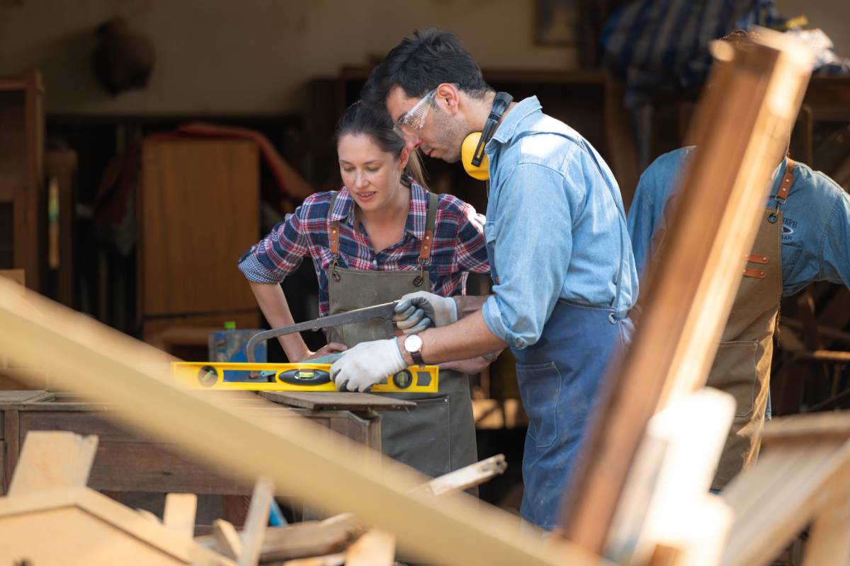 Carpenter and his assistant working together in a carpentry workshop