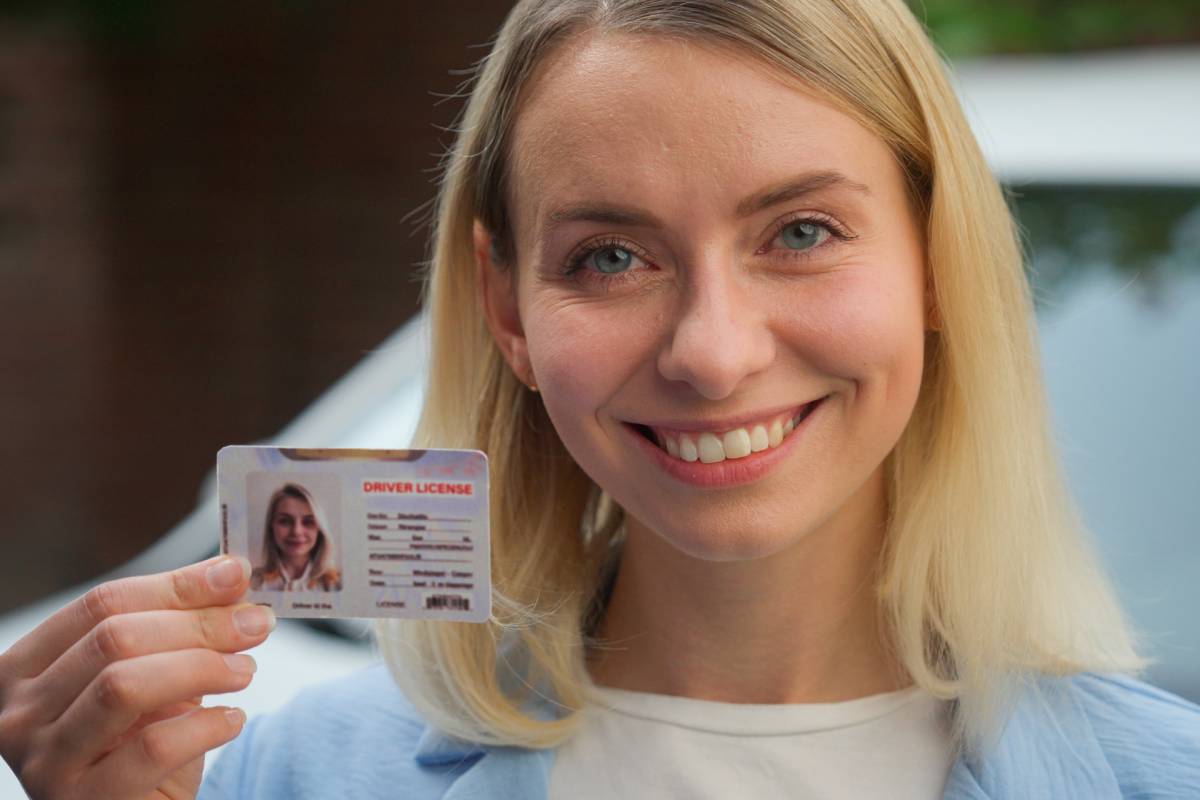 Cheerful Caucasian lady smiling female girl auto transport owner demonstrating driver license in camera in city client happy woman showing document car automobile insurance vehicle rent driving school