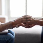 Therapist holding hands of man patient provide psychological help, cropped
