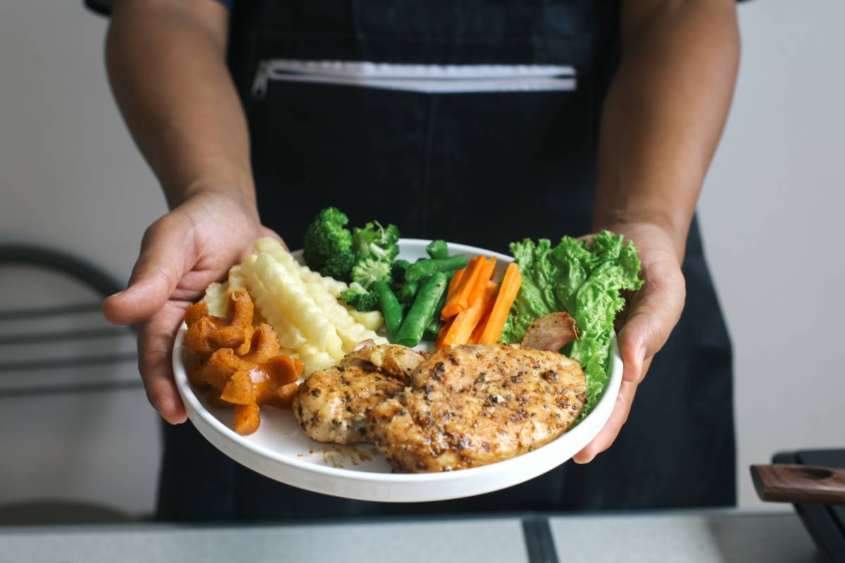 hands-holding-and-showing-chicken-steak-with-salad-2025-03-16-04-38-06-utc (1)