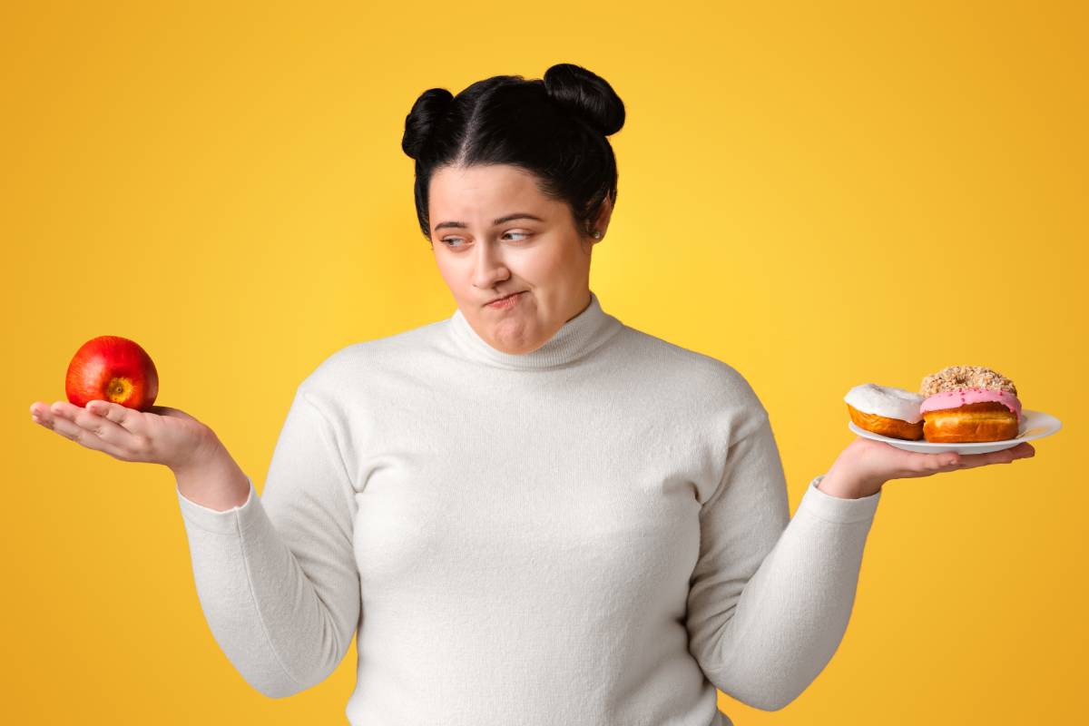 Hungry Obese Girl On Diet Making Choice Between Donuts And Apple
