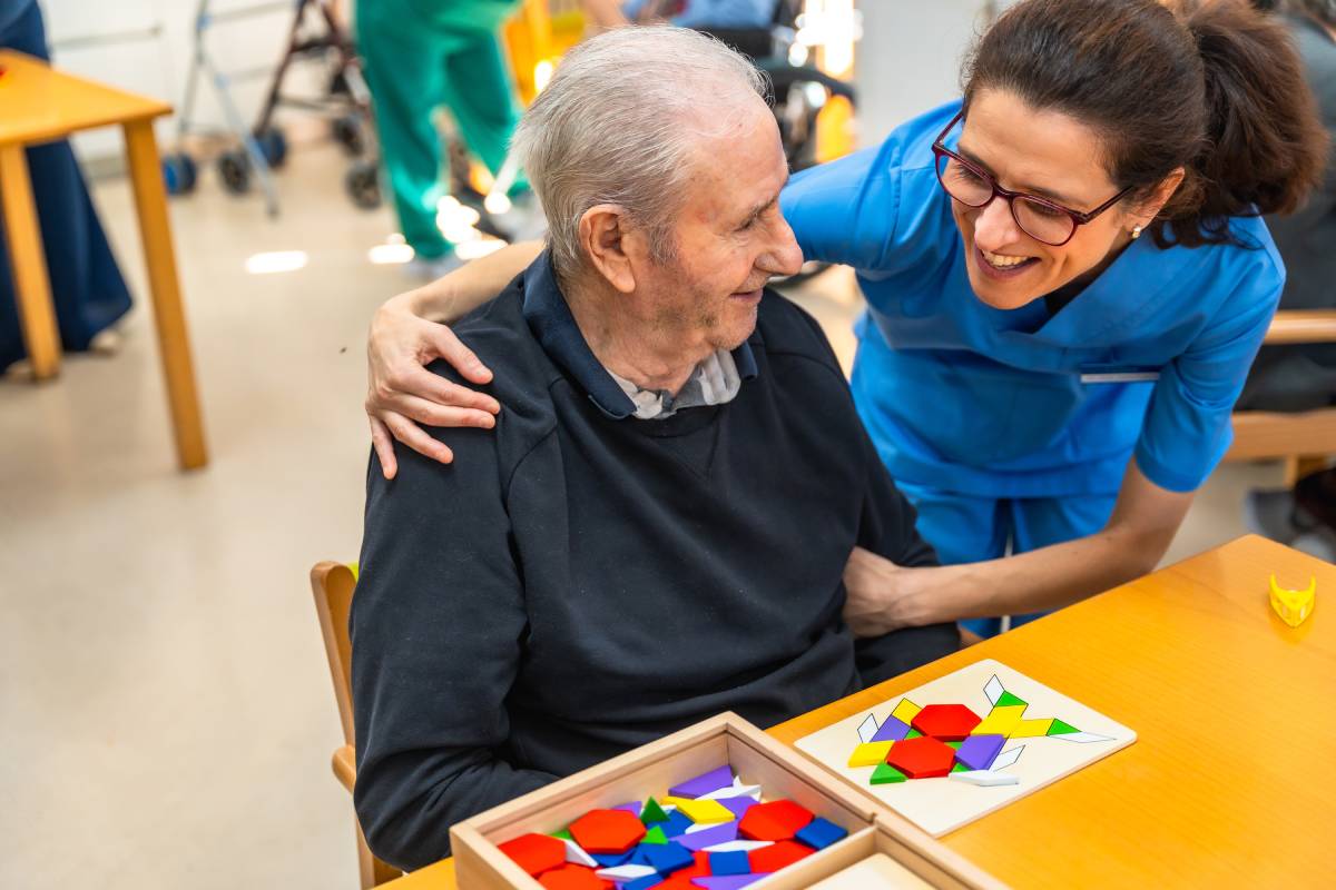 Senior man having fun with nurse playing board skill games
